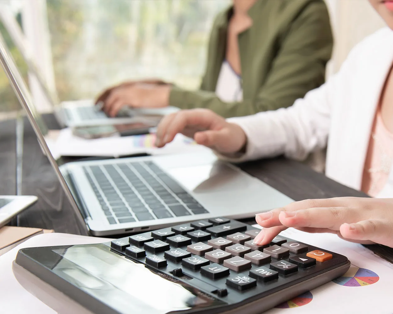 A woman is using a calculator at an accounting firm.