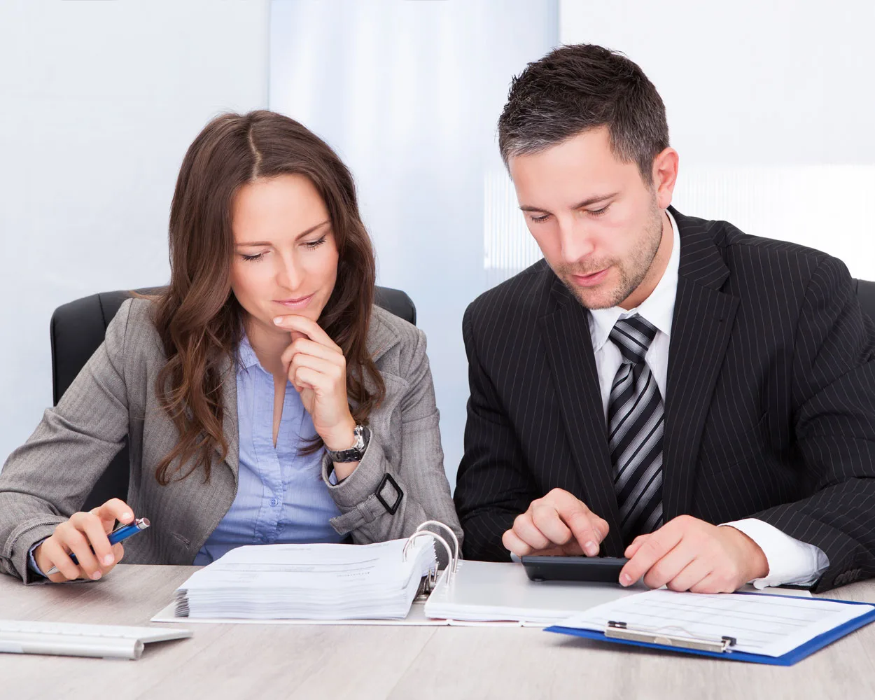 A businessman and a woman are working on a spreadsheet.